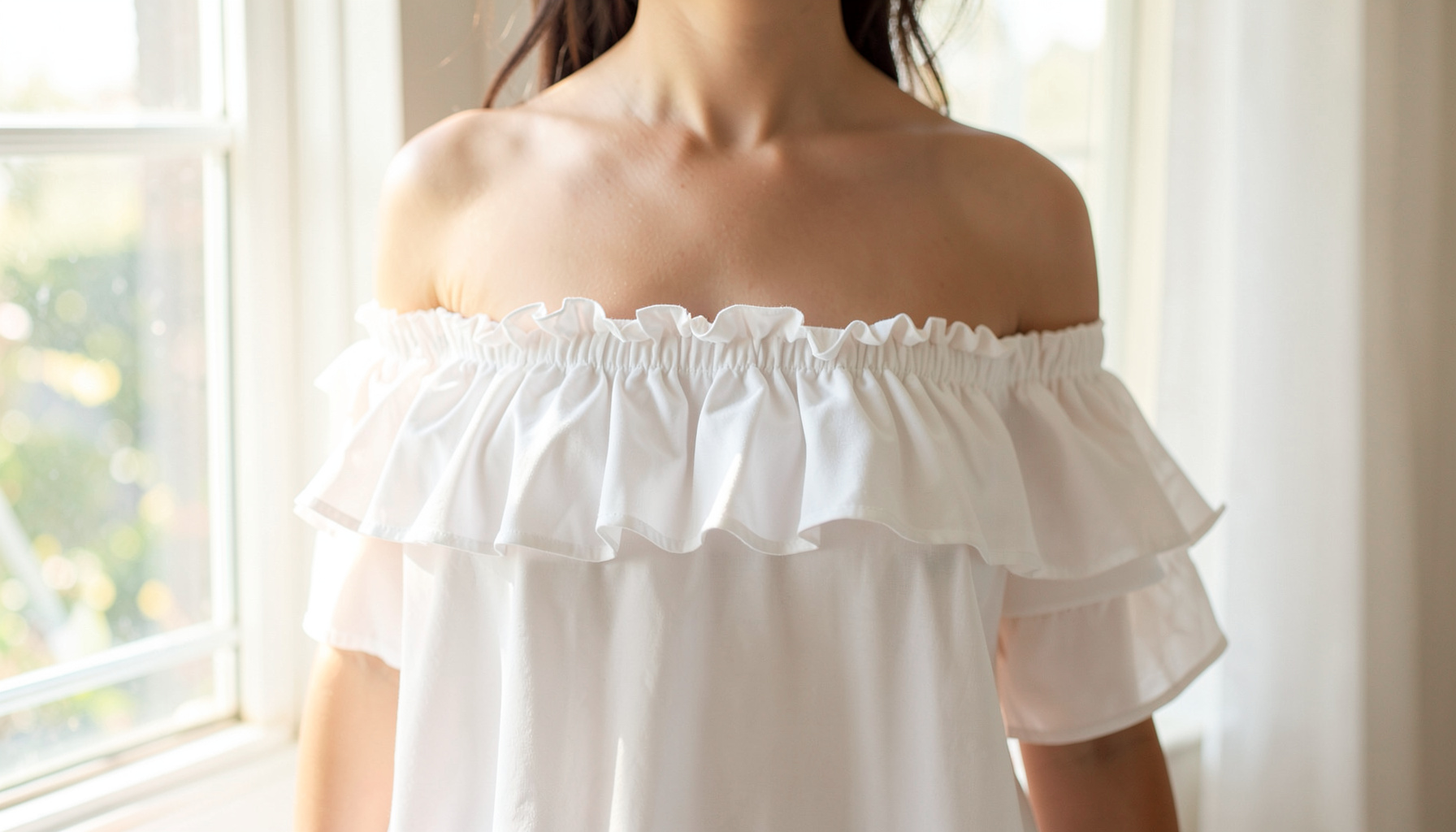 Off-the-shoulder white top with soft ruffles, photographed against a sunlit window, airy and romantic